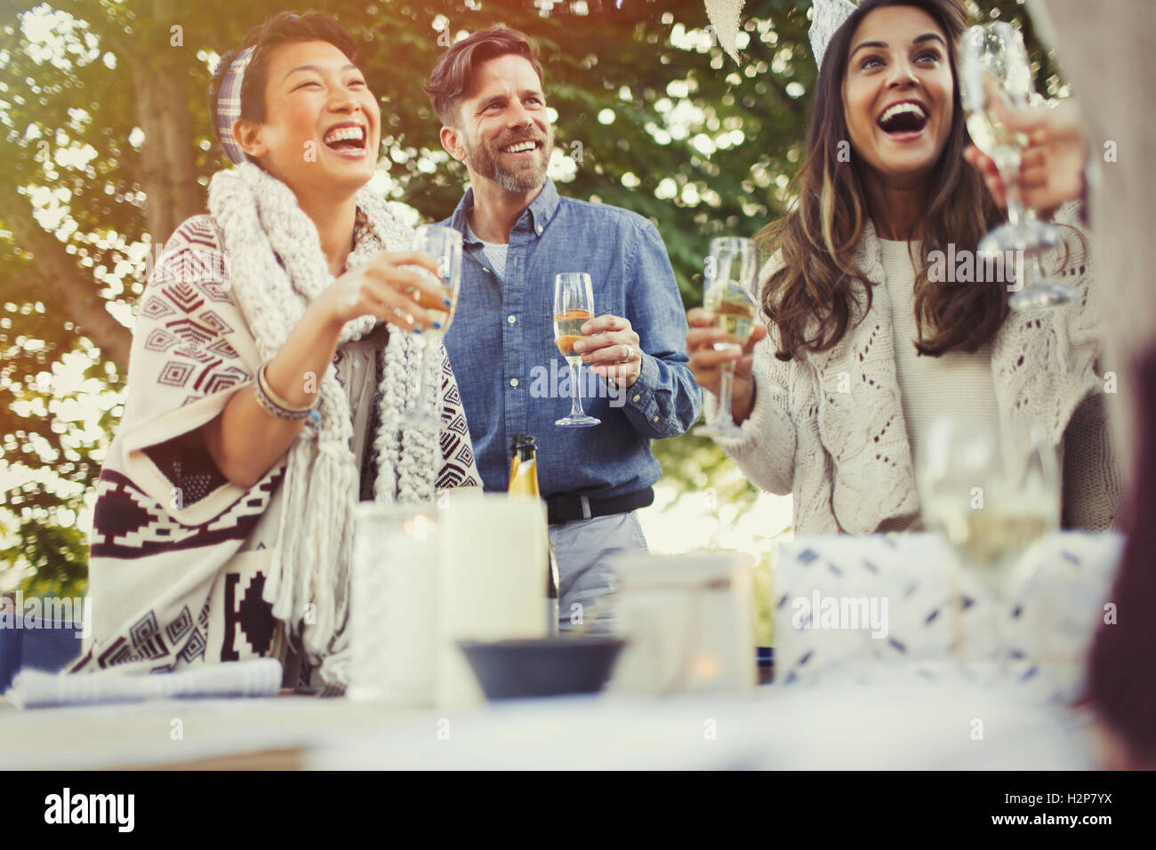 Friends laughing and drinking champagne at birthday party Stock Photo