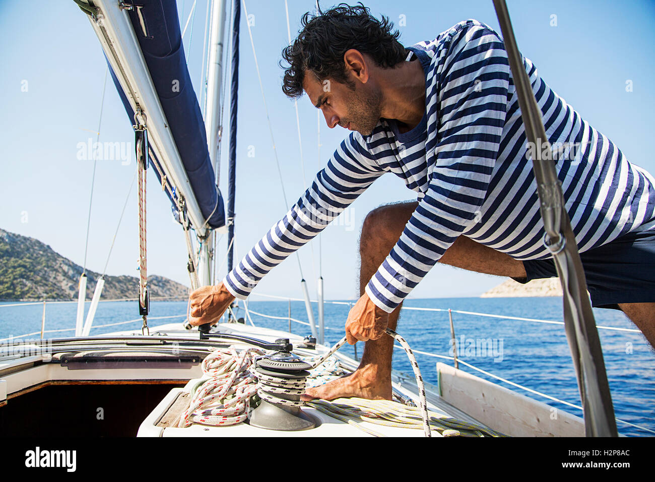 Young handsome sailor pulling rope on sailboat Stock Photo Alamy