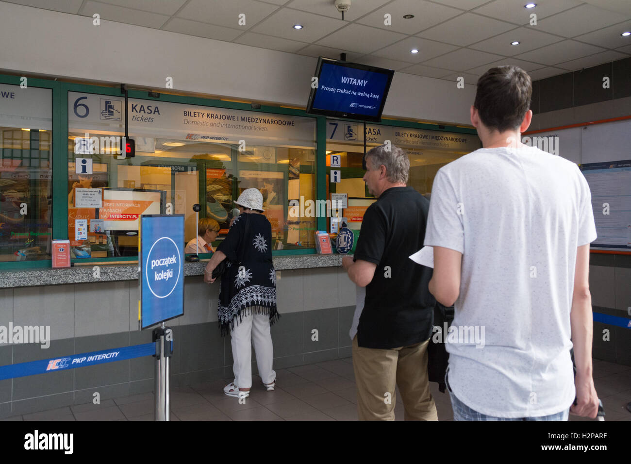woman buying tickets from the ticket desk at Glowny station, Gdansk, Poland Stock Photo