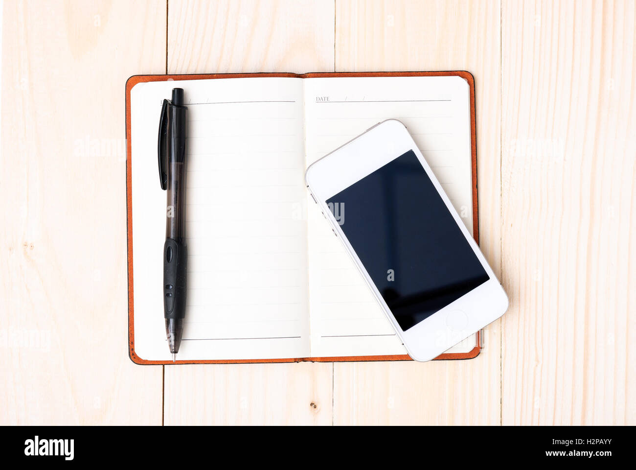 Small notepad with pen and smartphone Stock Photo - Alamy