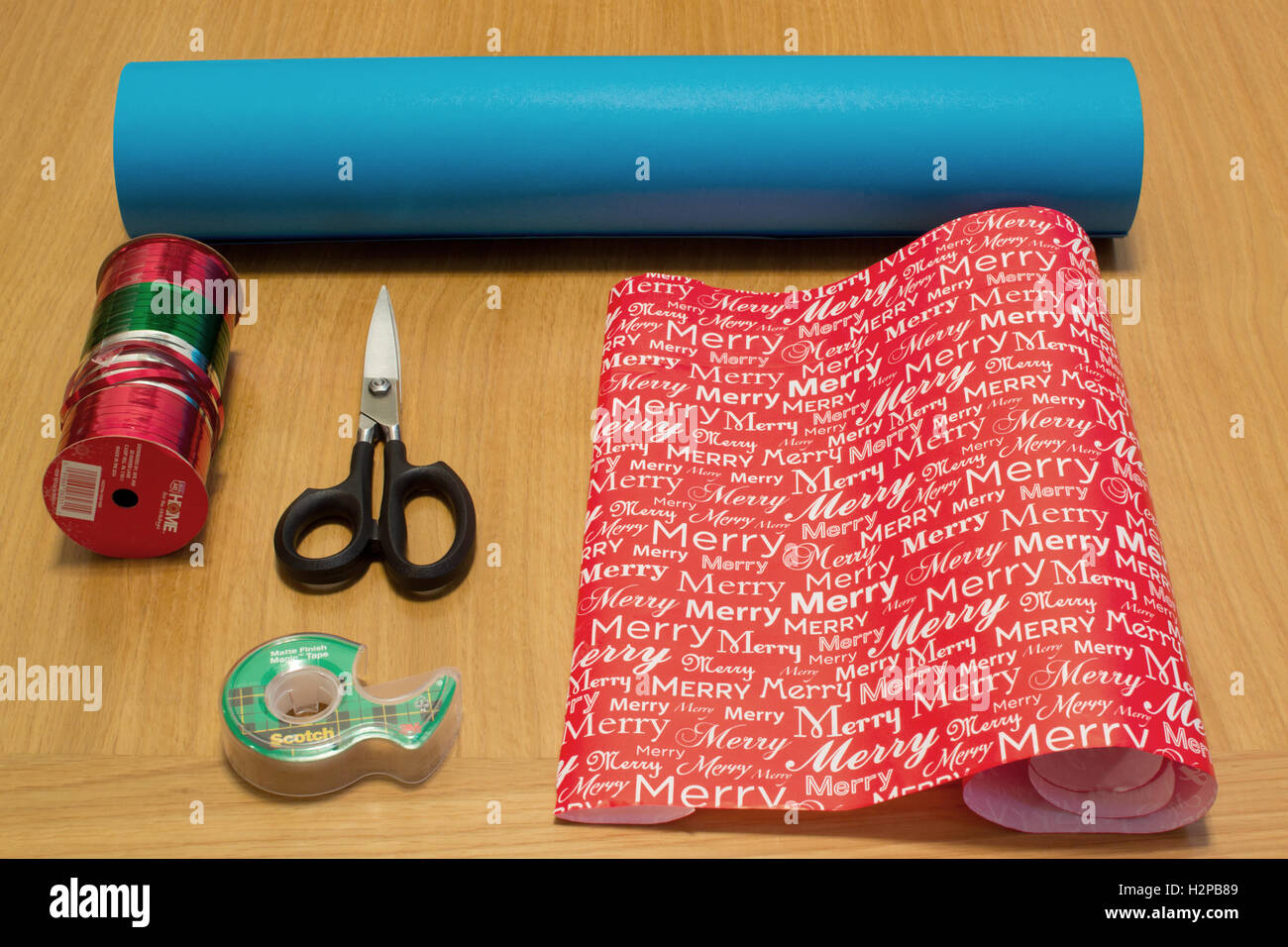 Getting organized: Paper wrap with Christmas theme, scotch tape, scissors  and ribbons for present wrapping, viewed from above Stock Photo - Alamy