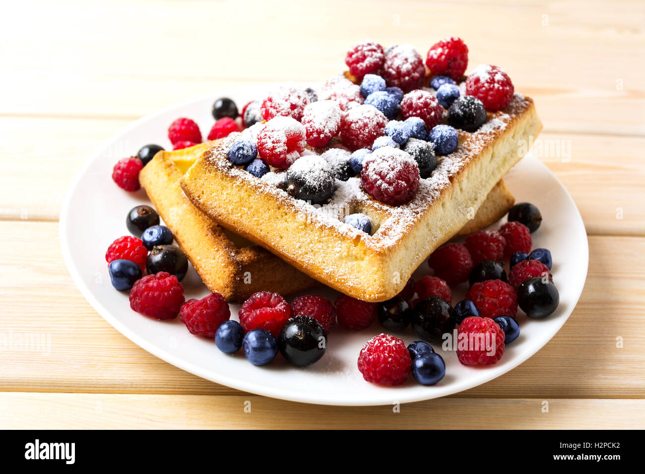 Soft waffles with blueberry and raspberry. Breakfast soft waffles with fresh berries. Belgian waffles. Stock Photo