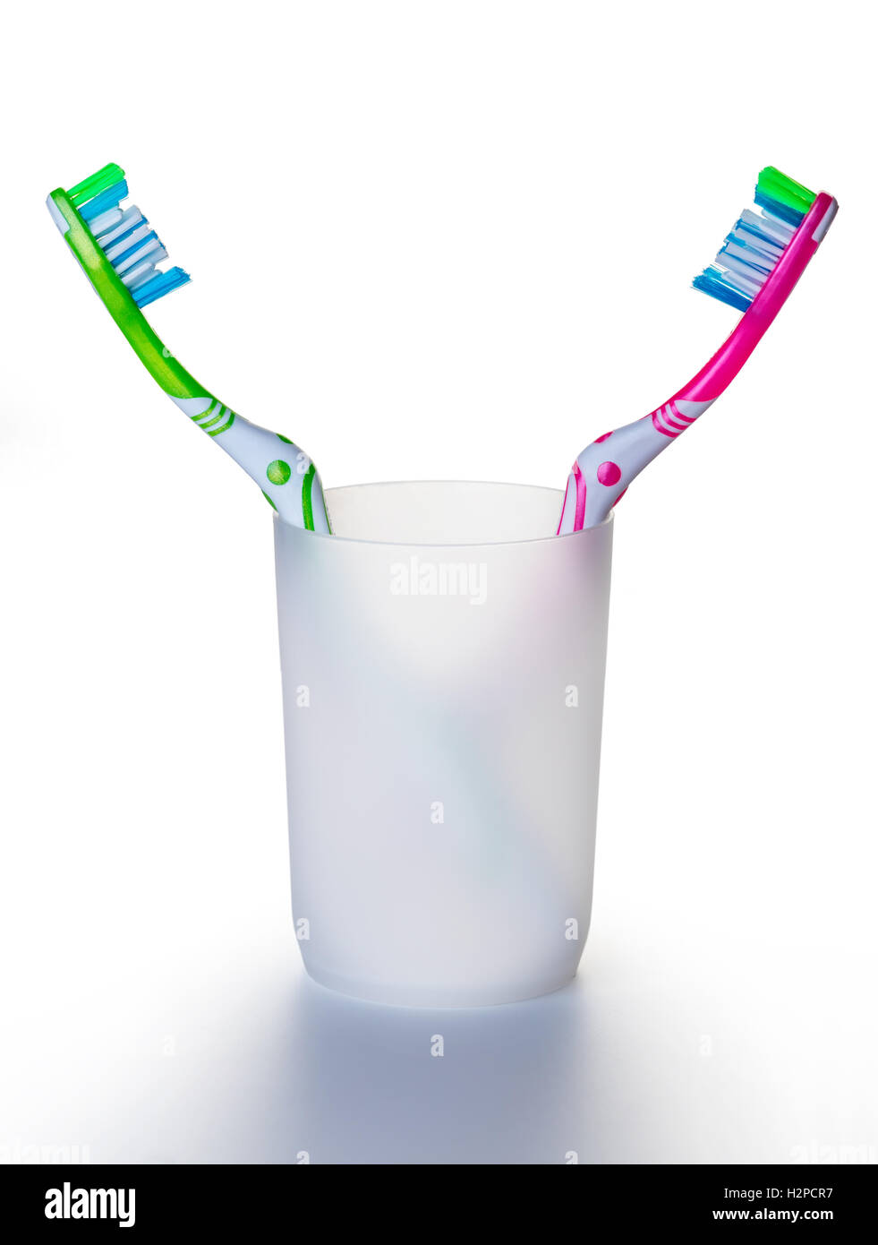 two toothbrushes in a glass on white background Stock Photo - Alamy