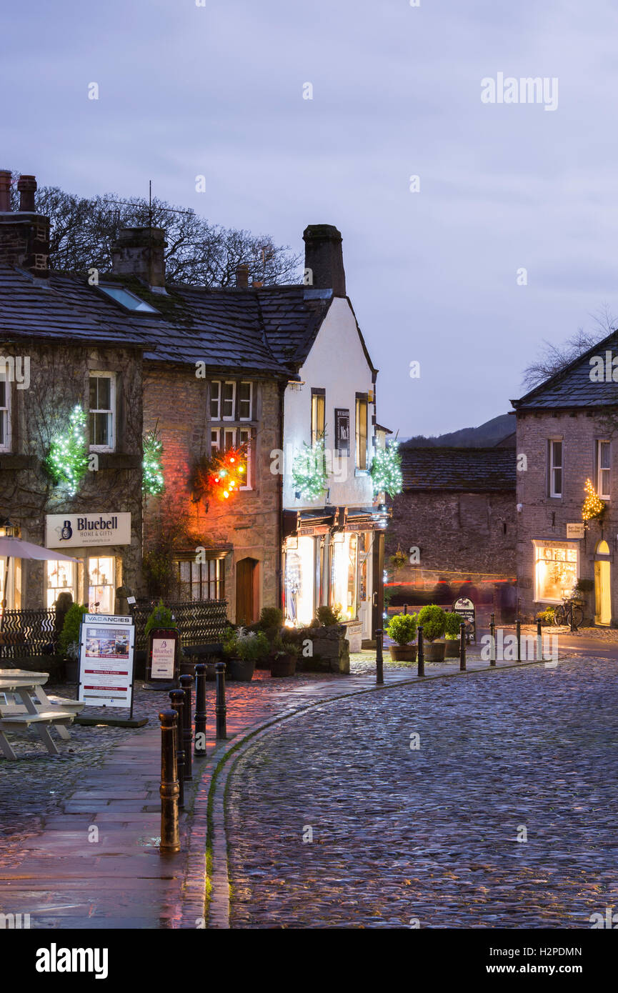 Colourful Christmas lights brighten up a dark winter's evening - Grassington Village, Yorkshire Dales National Park, England. Stock Photo
