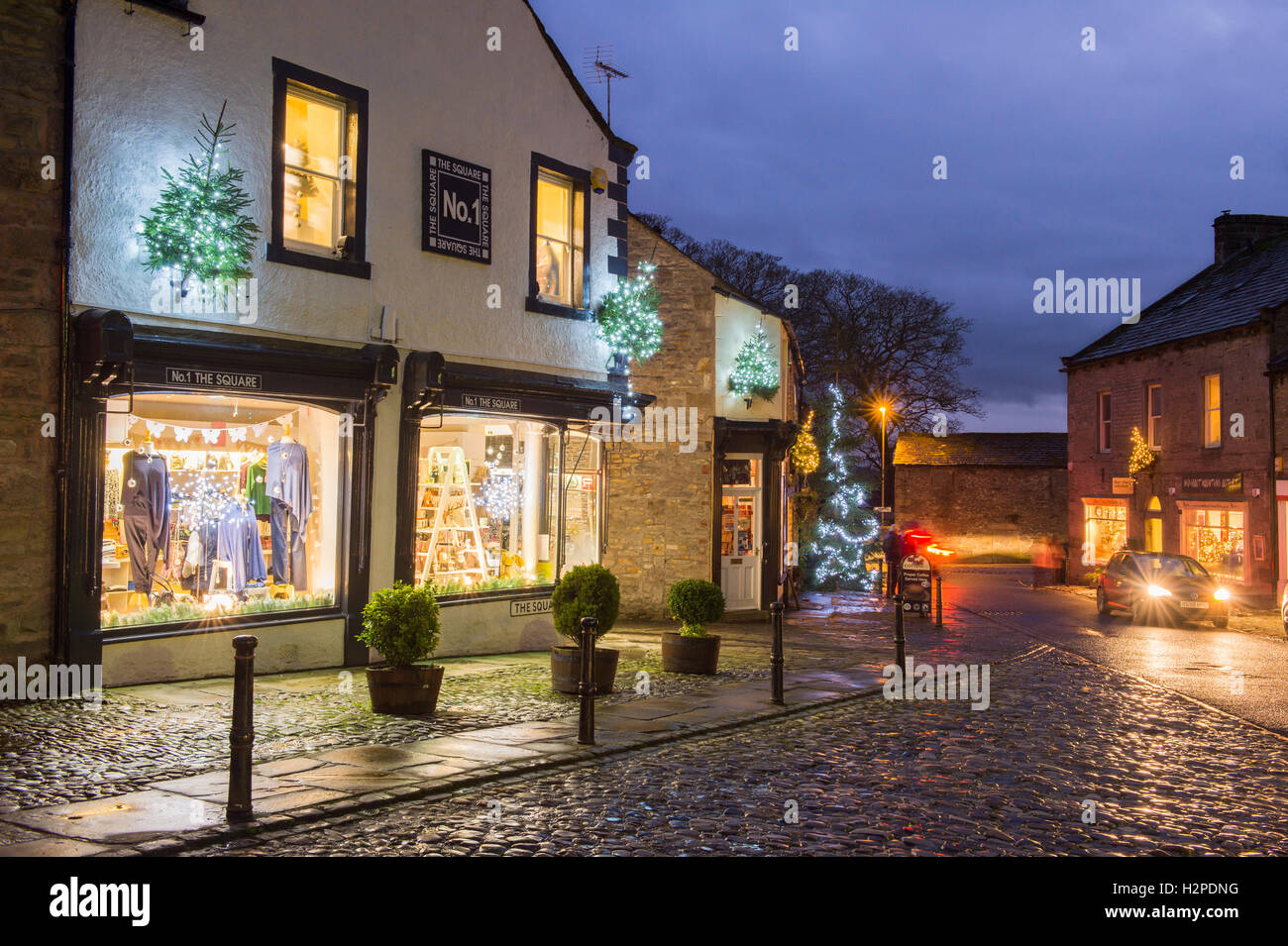 Colourful Christmas lights brighten up a dark winter's evening - Grassington Village, Yorkshire Dales National Park, England. Stock Photo