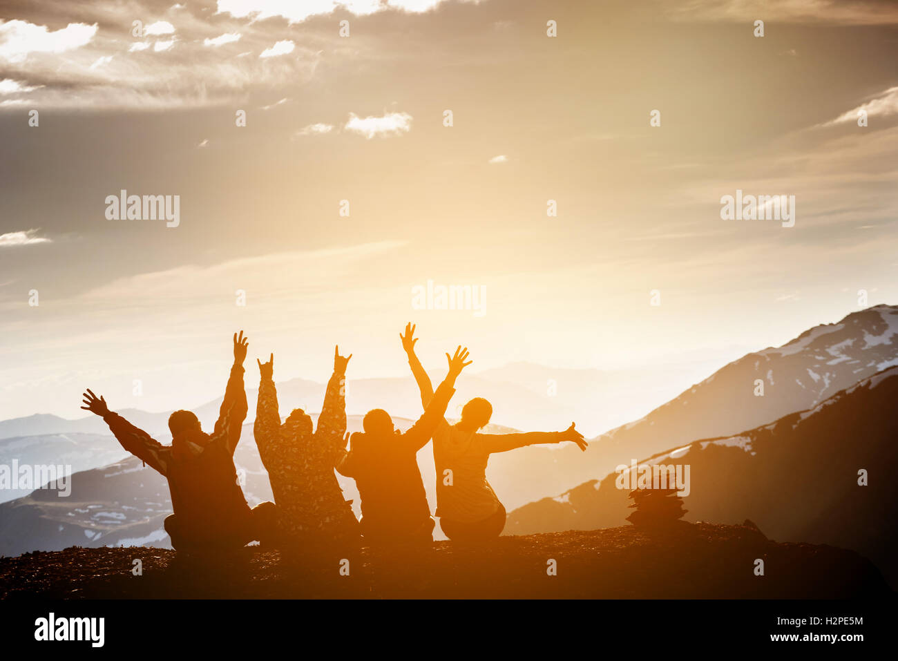 Group of friends sits on the top  mountain and having fun Stock Photo