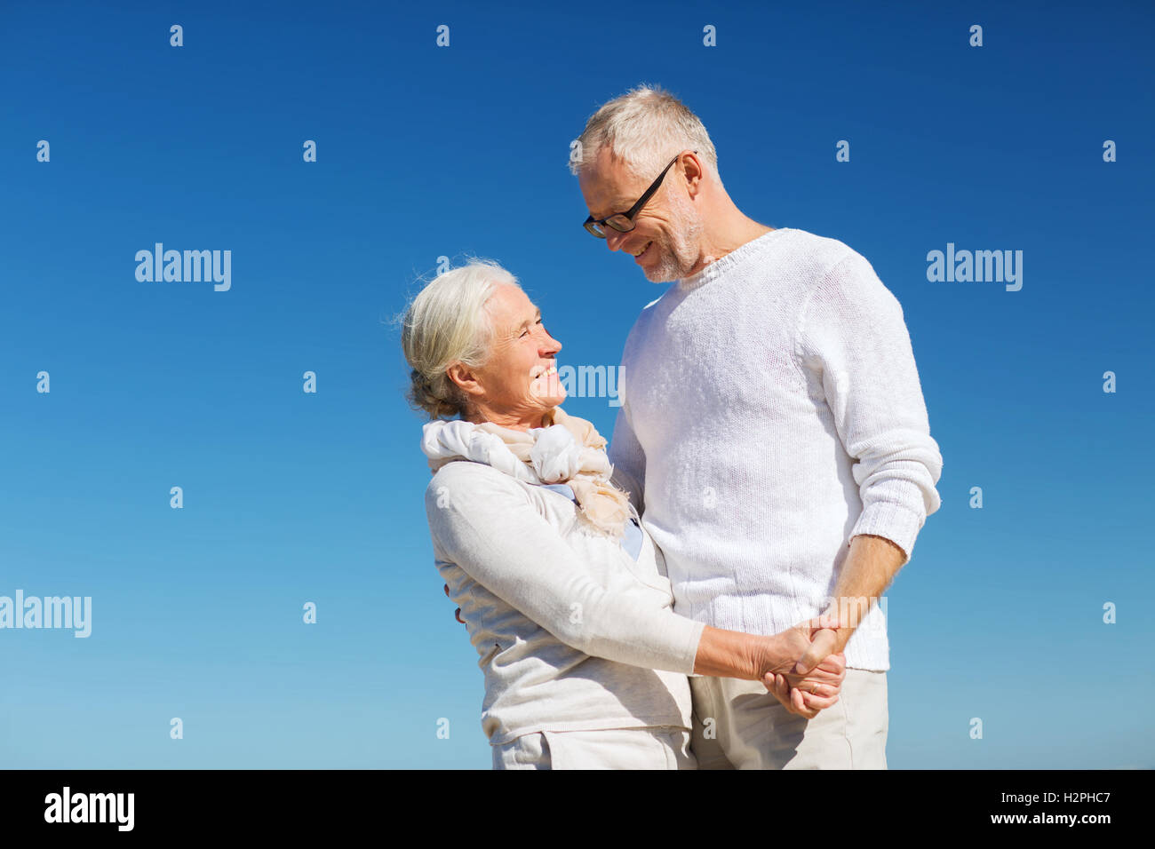 happy senior couple holding hands on summer beach Stock Photo - Alamy