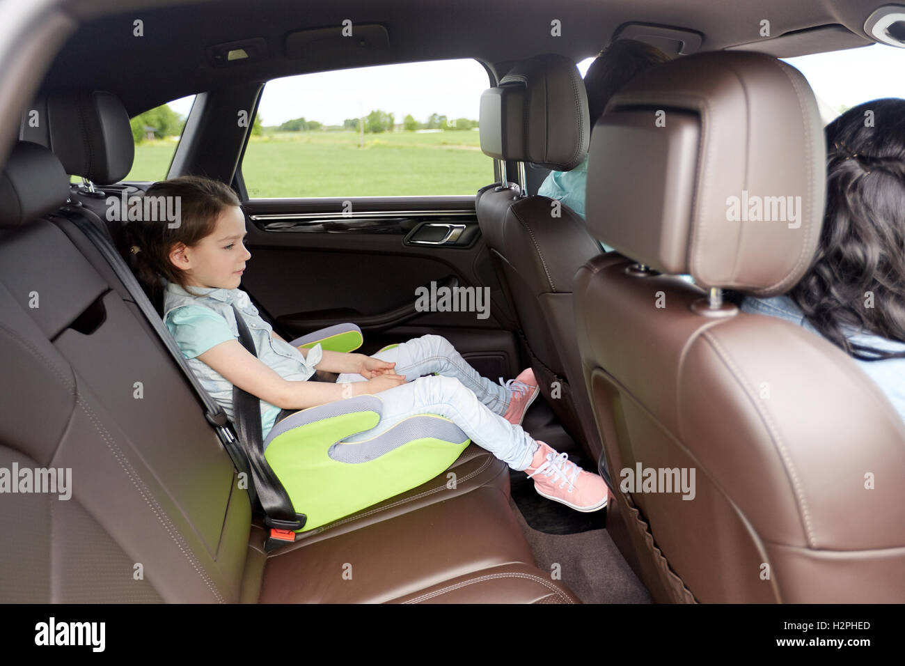 family with child in safety seat driving car Stock Photo