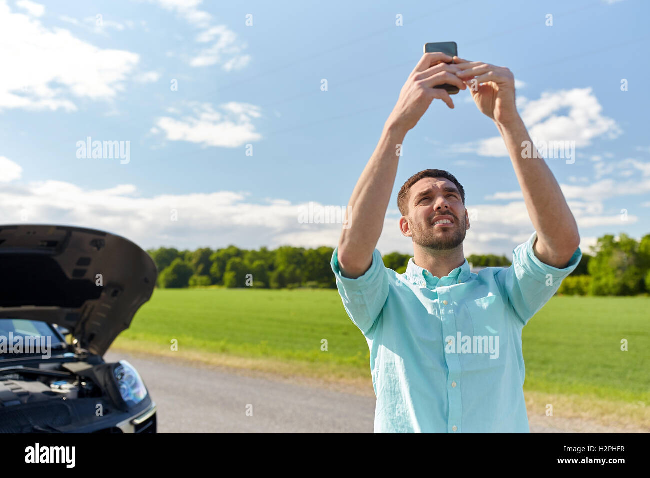 man with smartphone and broken car at countryside Stock Photo
