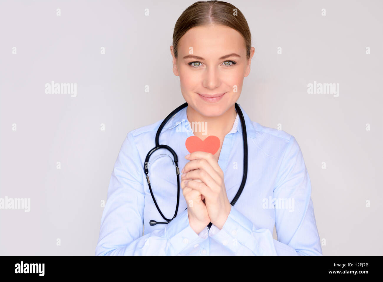 Good cardiologist, portrait of a nice doctor with conceptual heart in hands over clean background Stock Photo