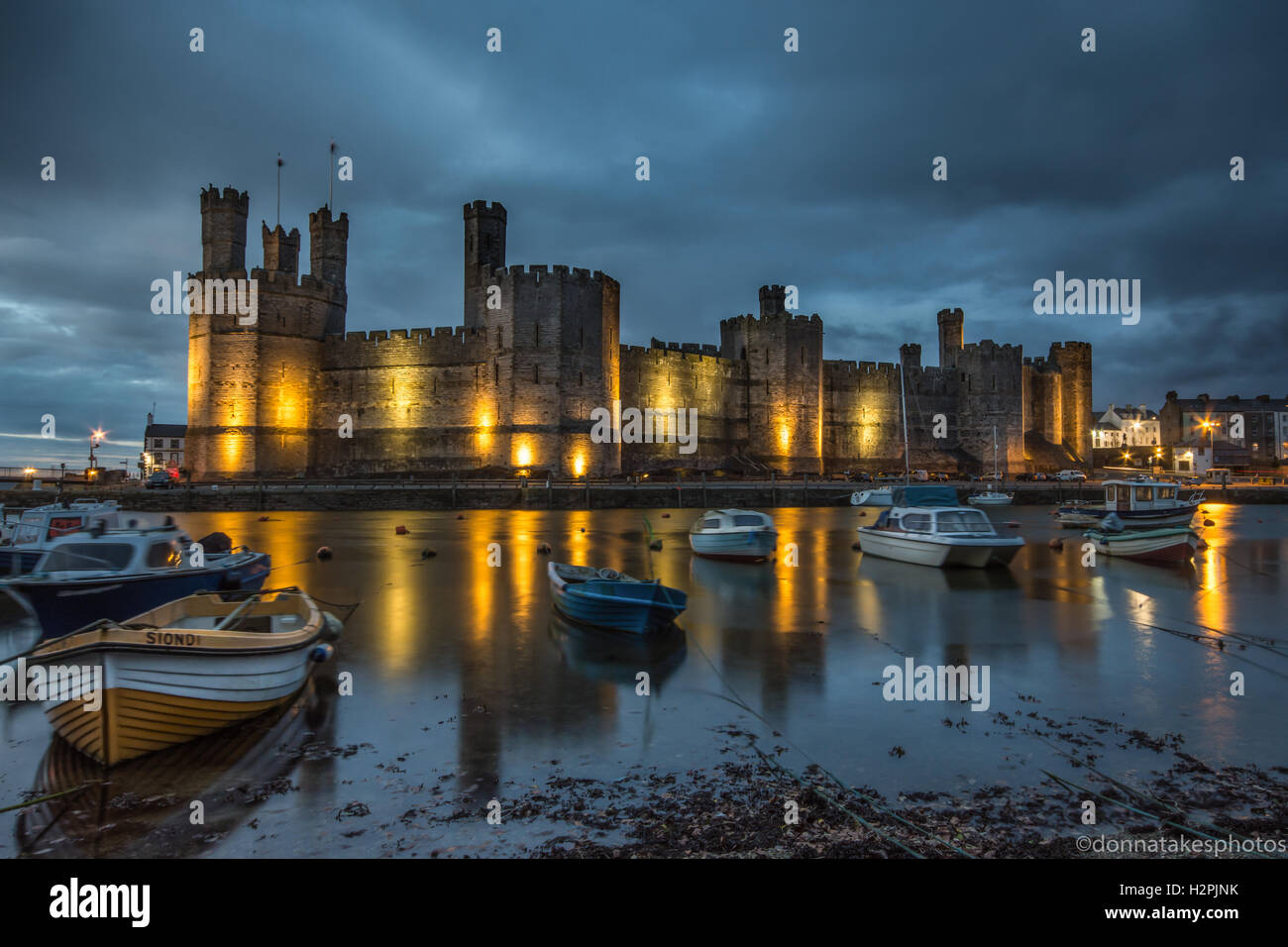 Caernarfon Castle lit up at night, England, UK Stock Photo