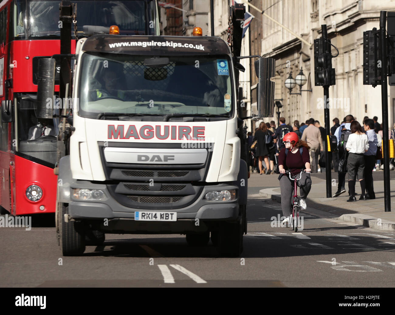 A lorry overtaking a cyclist in Parliament Square, Westminster, London. Thousands of lorries could be banned from London under plans to make the capital's roads safer for cyclists. Stock Photo