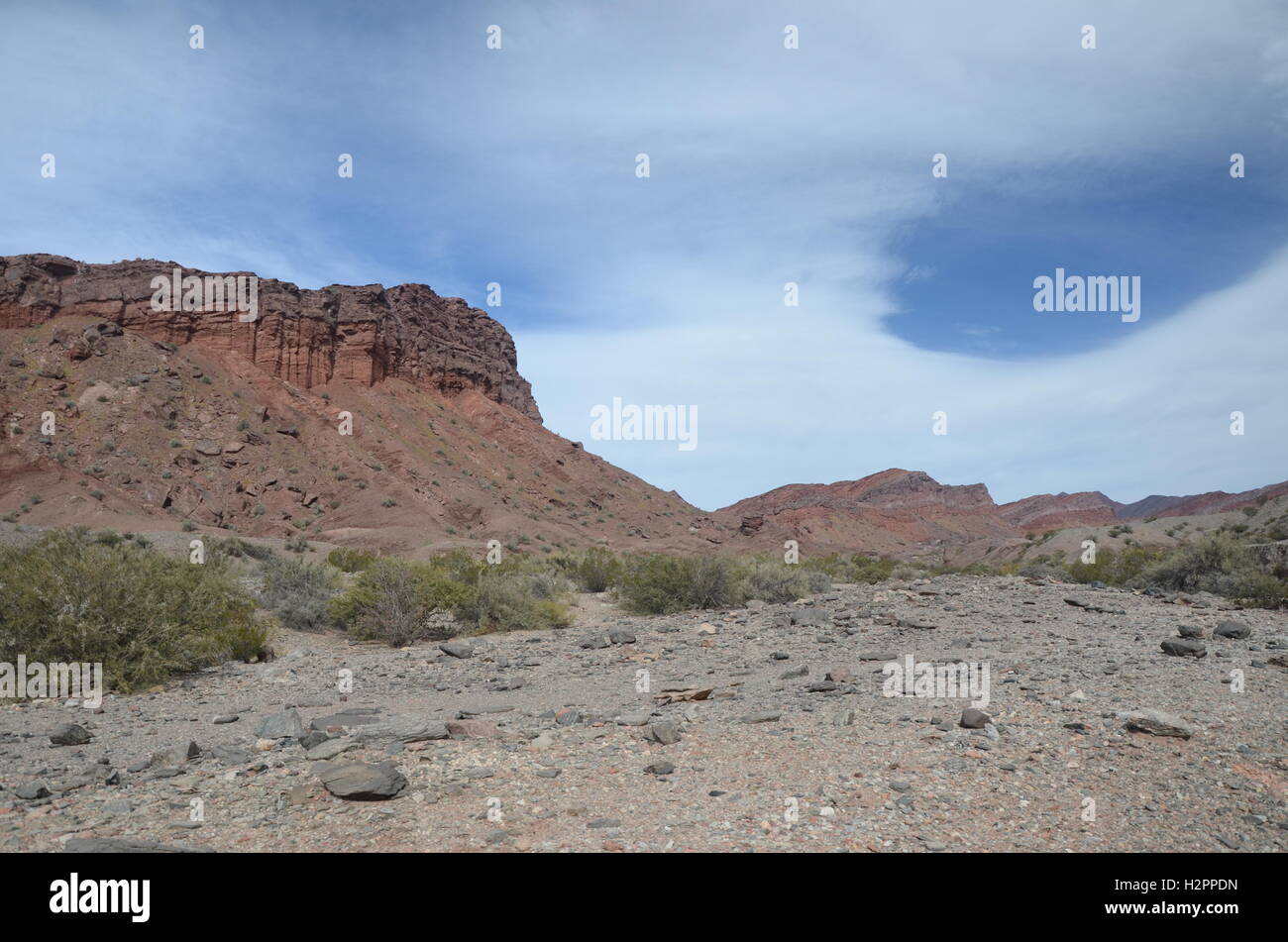 Desert and cliff and thin white clouds Stock Photo