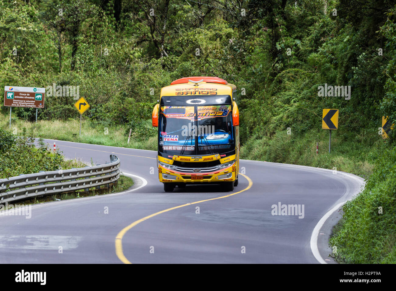 A passenger bus driving on mountain highway in the Andes. Ecuador, South America. Stock Photo