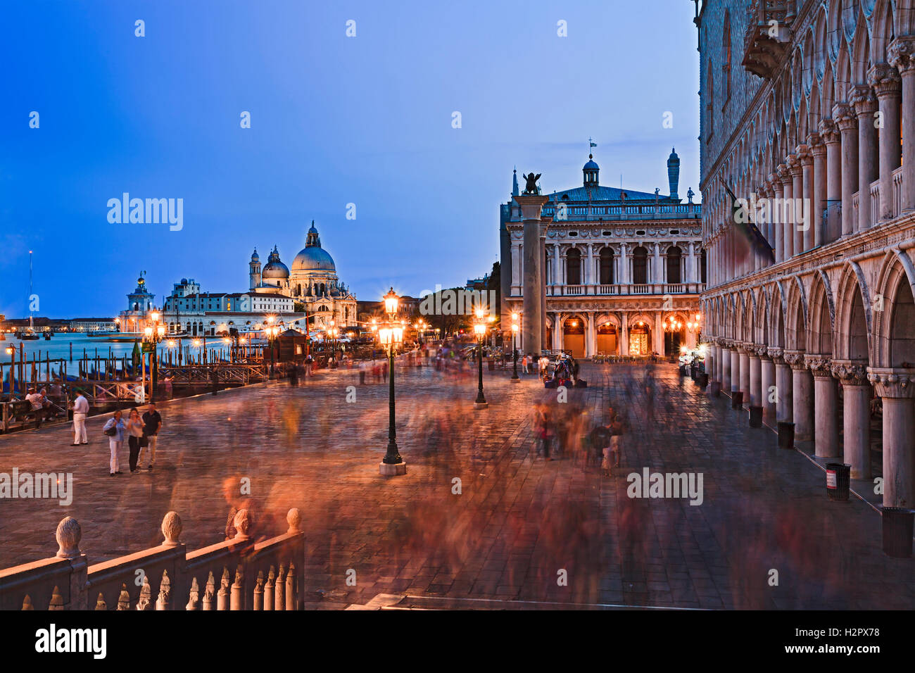 San Marco square of Venice at sunset along Doges palace towards Gondola service piers and Di Santa Maria catherdal. blurred crow Stock Photo