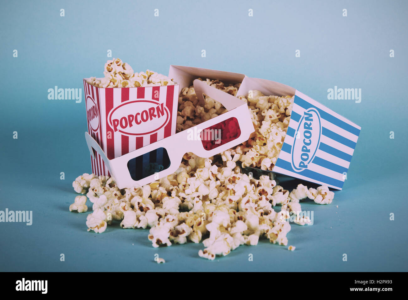 Bucket of popcorn against a blue background Vintage Retro Filter. Stock Photo
