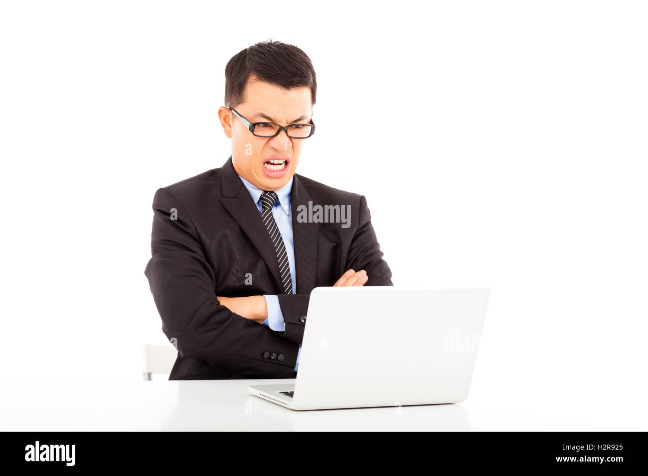 angry businessman look at laptop and cross arms Stock Photo - Alamy