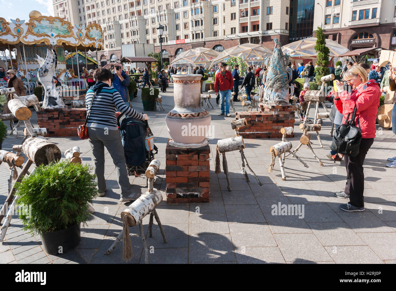 Moscow, Russia. Saturday, October 1, 2016. Warm and sunny weekend in Moscow, Russia. The temperature is as high as +18 degrees Centigrade (+64F). This is the last farewell to the warm season. Next week autumn will start to set in. Street and parks of the city are full of people. Unidentified people enjoy trade fair on Revolution square of Moscow, which is decorated by the folk art pieces and trade pavilions. Credit:  Alex's Pictures/Alamy Live News Stock Photo