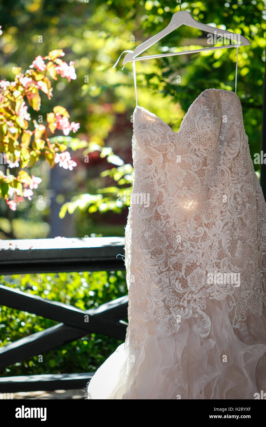 Wedding dress hanging outside on a hanger Stock Photo - Alamy