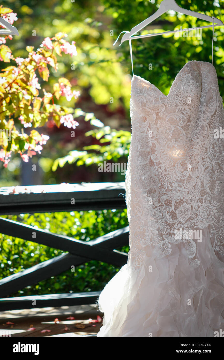 Wedding dress hanging outside on a hanger Stock Photo - Alamy