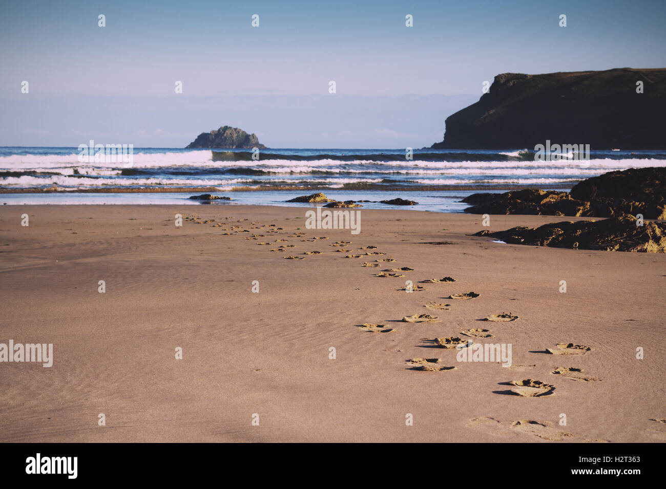 Footprints in the sand on Polzeath beach, Cornwall Vintage Retro Filter. Stock Photo