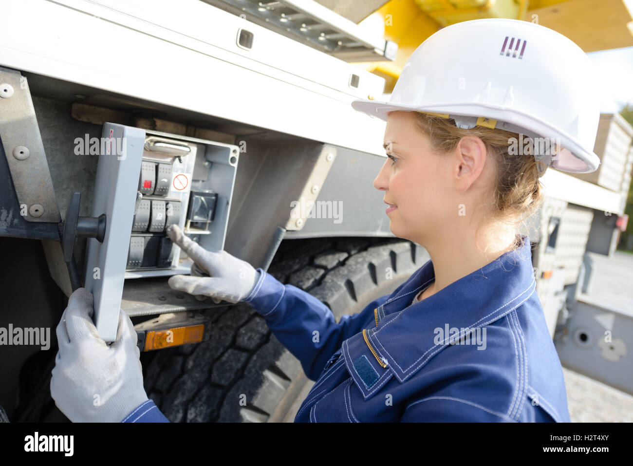 Woman operating controls on side of crane Stock Photo - Alamy