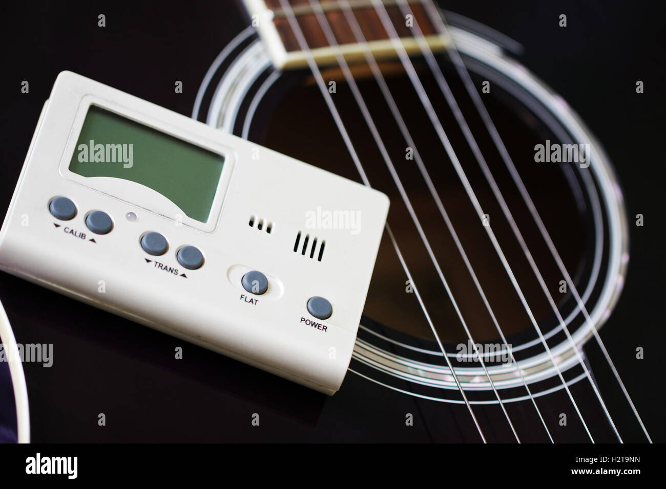 Guitar and tuner for toning musical instruments Stock Photo