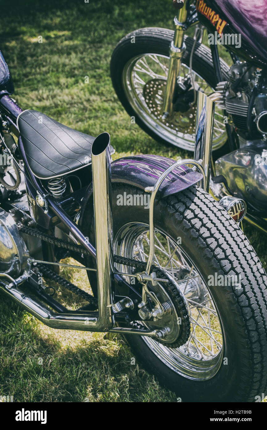 Custom exhaust pipes on a custom British bobber motorcycle. Vintage filter applied Stock Photo