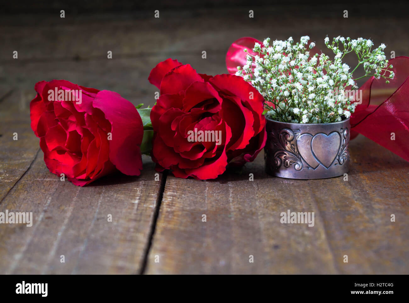Romantic background with bright red roses and white flowers on rustic ...