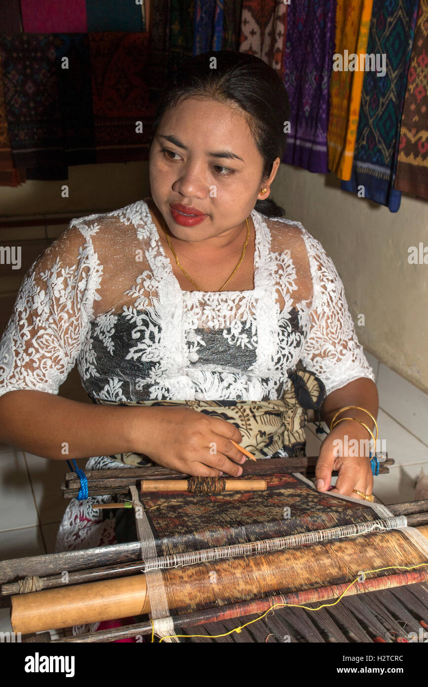 Indonesia, Bali, Tengannan, traditional textile production, woman hand weaving double ikat fabric on backstrap loom Stock Photo