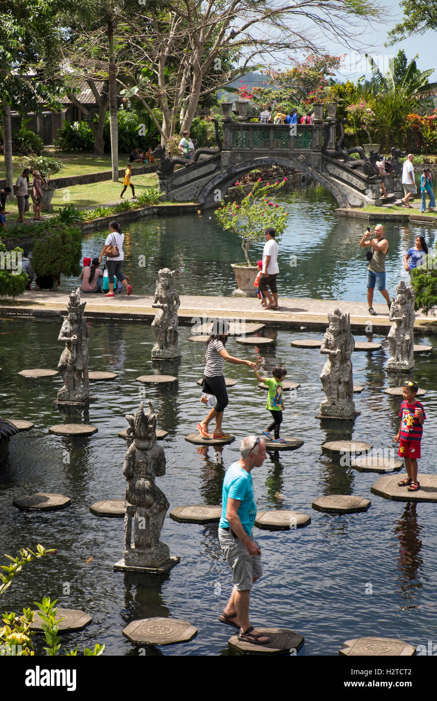 Indonesia, Bali, Tirta Gangga, tourists on water garden stepping stones Stock Photo