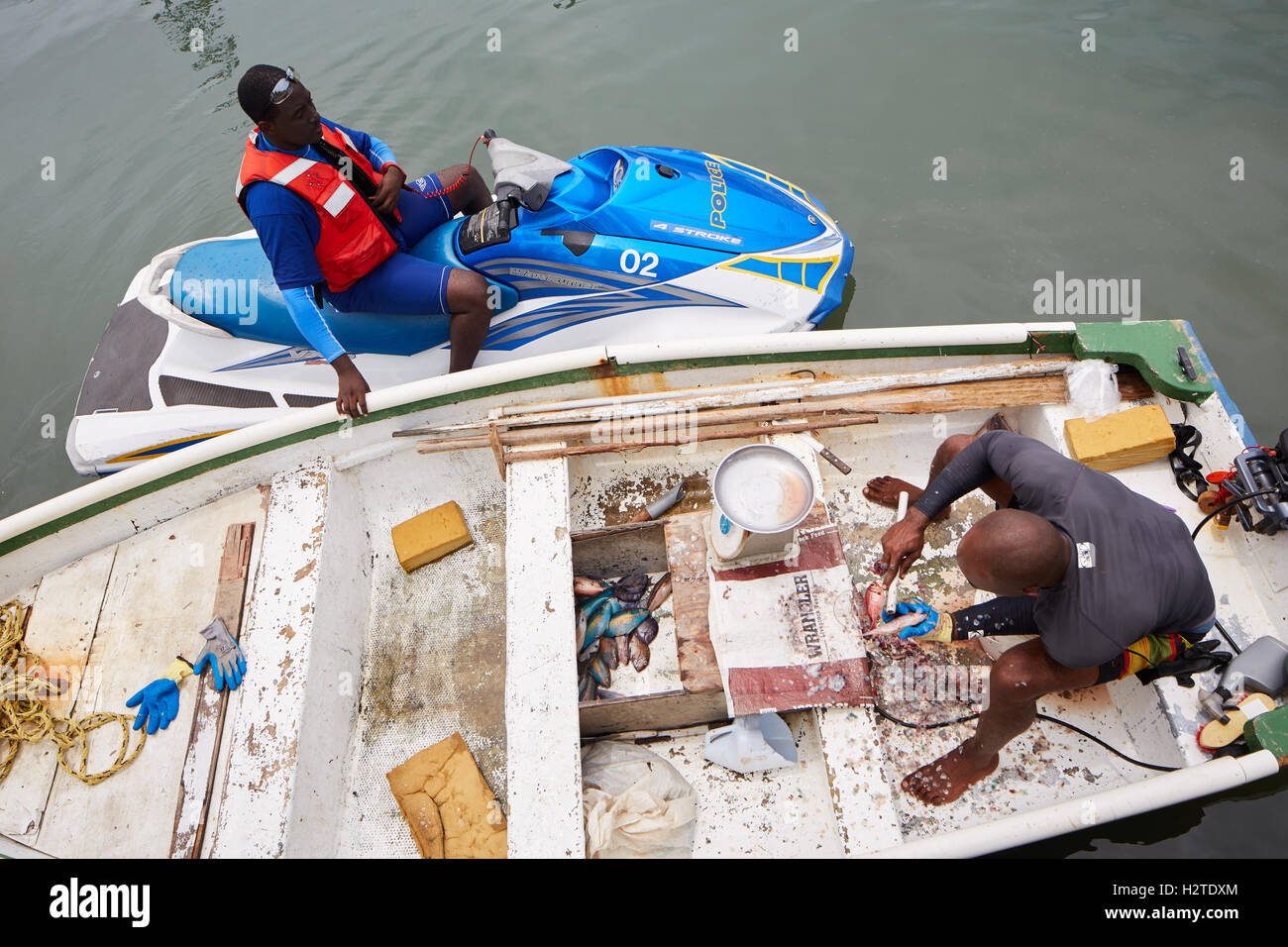 Barbados fisherman boat fishing police   scrapping local business trader man rowing boat worker workman fish caught Poor rundown Stock Photo