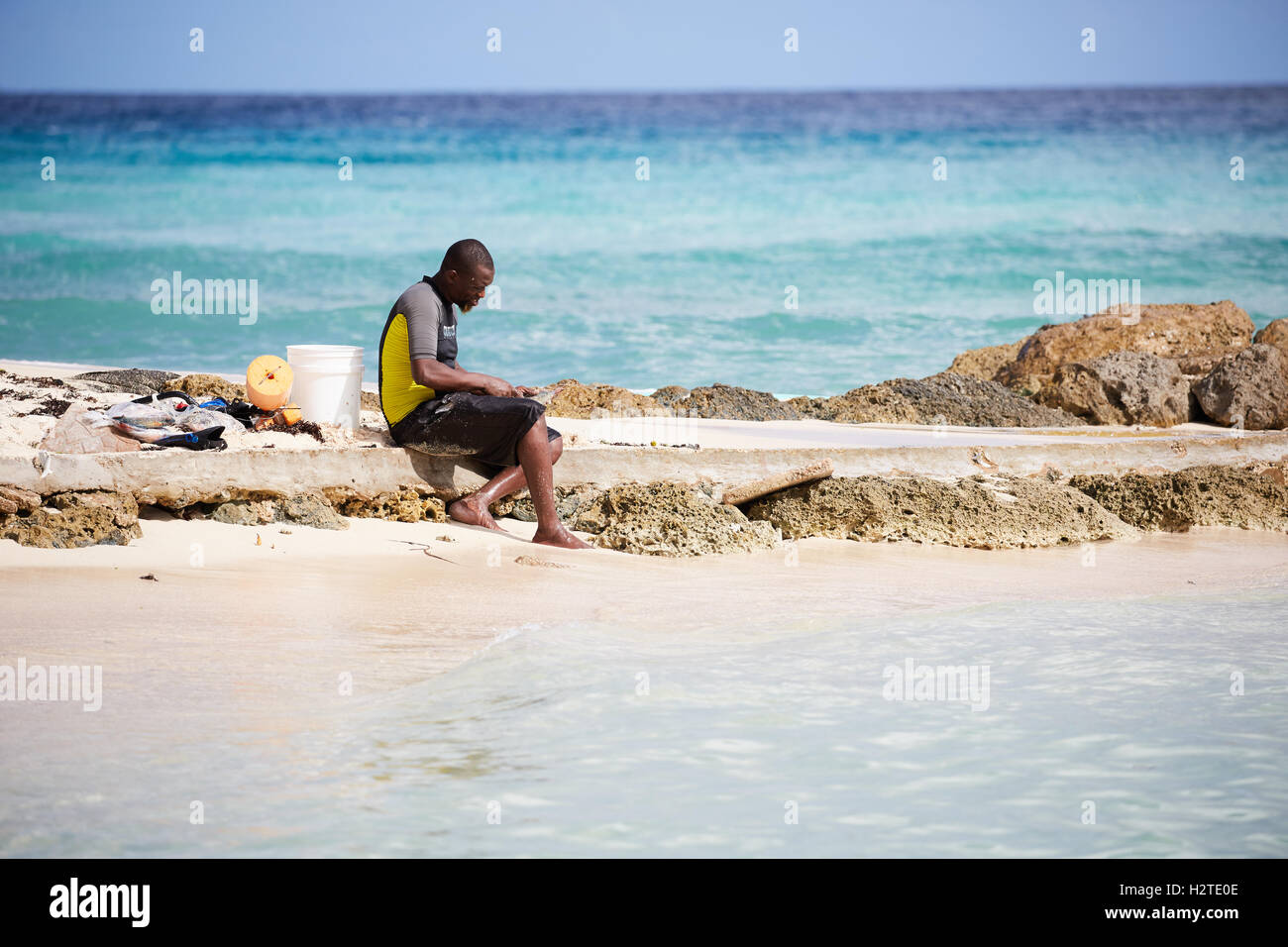 Barbados Hastings Bay fisherman  Young black male boy native fishing on the beach sea Poor rundown rubbish scruffy deprived comm Stock Photo