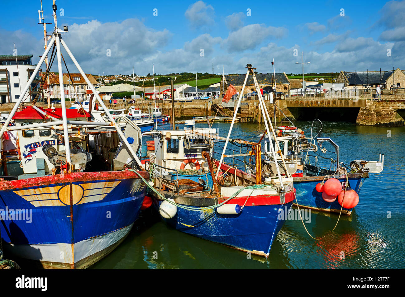 West Bay in Dorset is a small working harbour seen here with a mix of working fishing boats. The small harbour was central to the series Broadchurch. Stock Photo