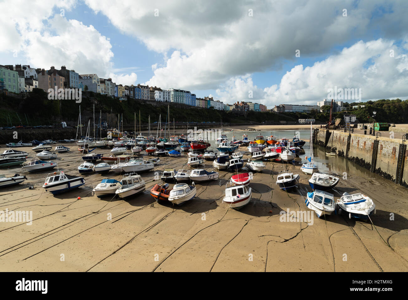 View of Tenby Harbour with fishing boats lined up awaiting the incoming tide, Pembrokeshire, Wales, Stock Photo