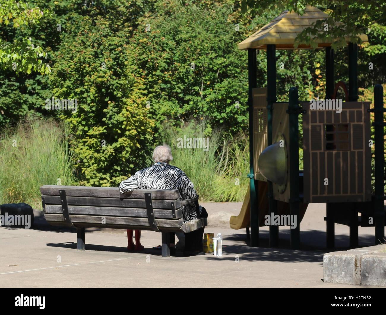 Elderly woman on a park bench enjoying the park Stock Photo