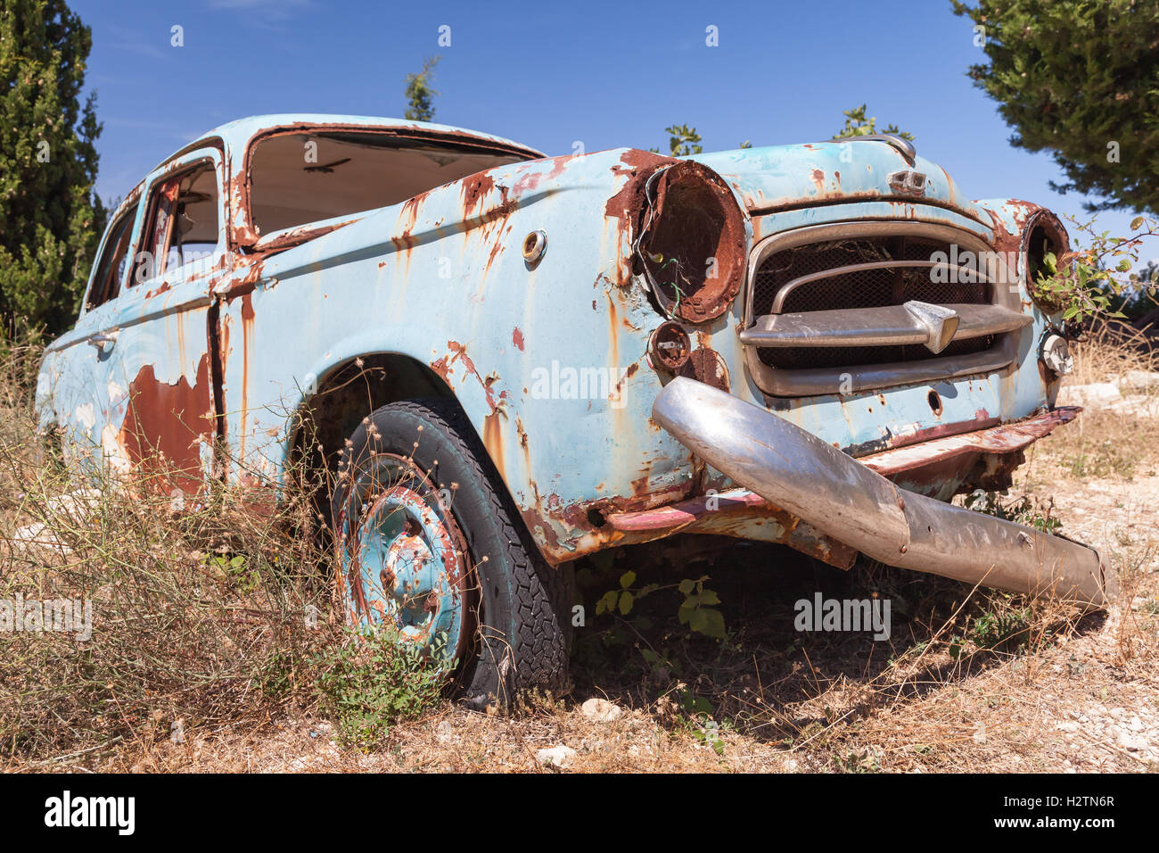 Zakynthos, Greece - August 20, 2016: Old abandoned vintage rusted car stands in summer garden Stock Photo