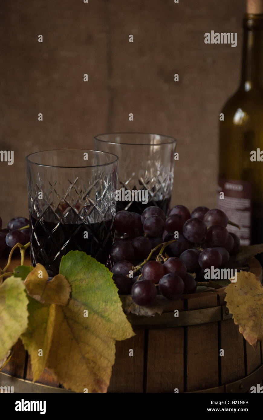 Two glasses with red wine, dry leaves and grapes on a wine barrel Stock ...
