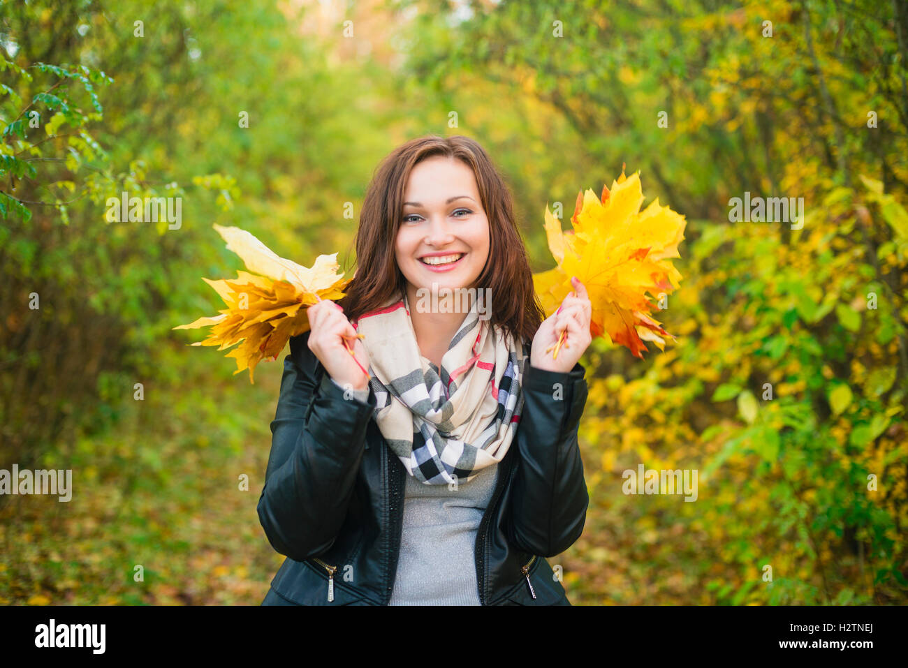 Young woman holding tree leaves in the hands and smiling Stock Photo ...