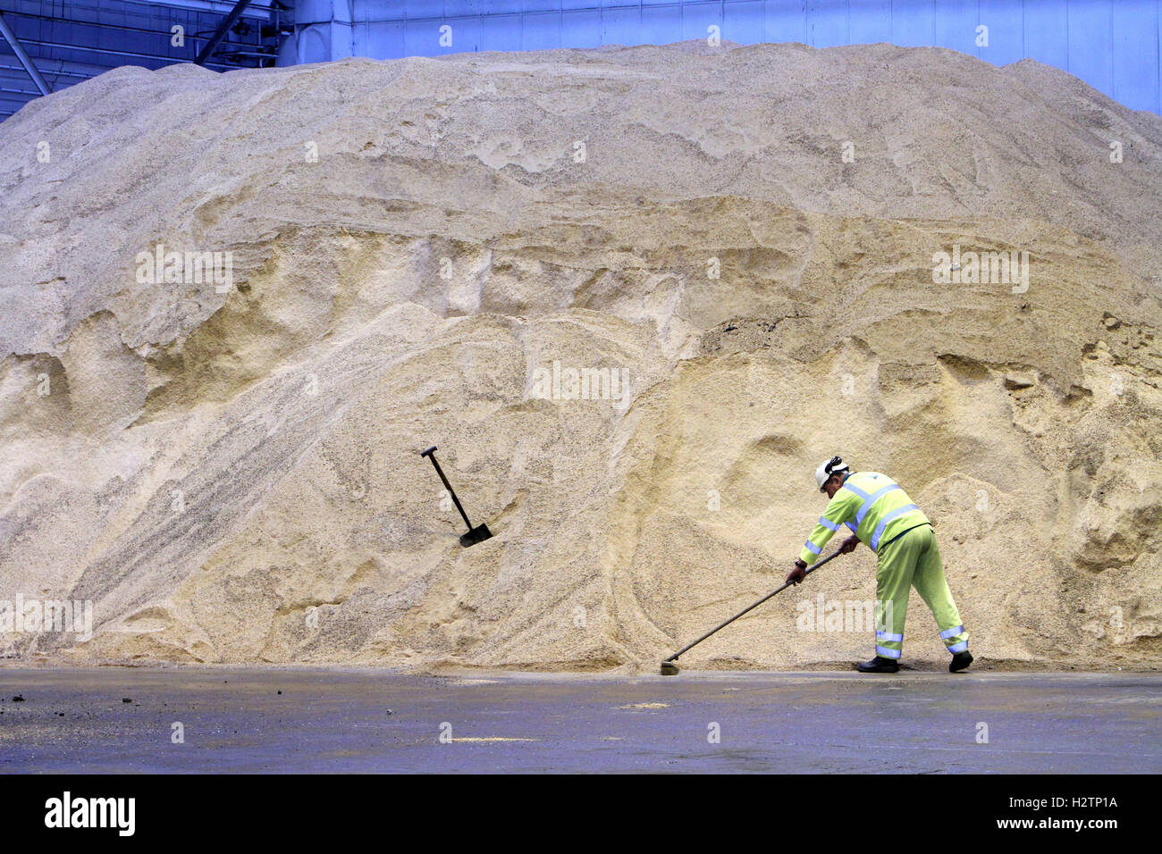 Transport worker with stock pile of road salt for winter Stock Photo