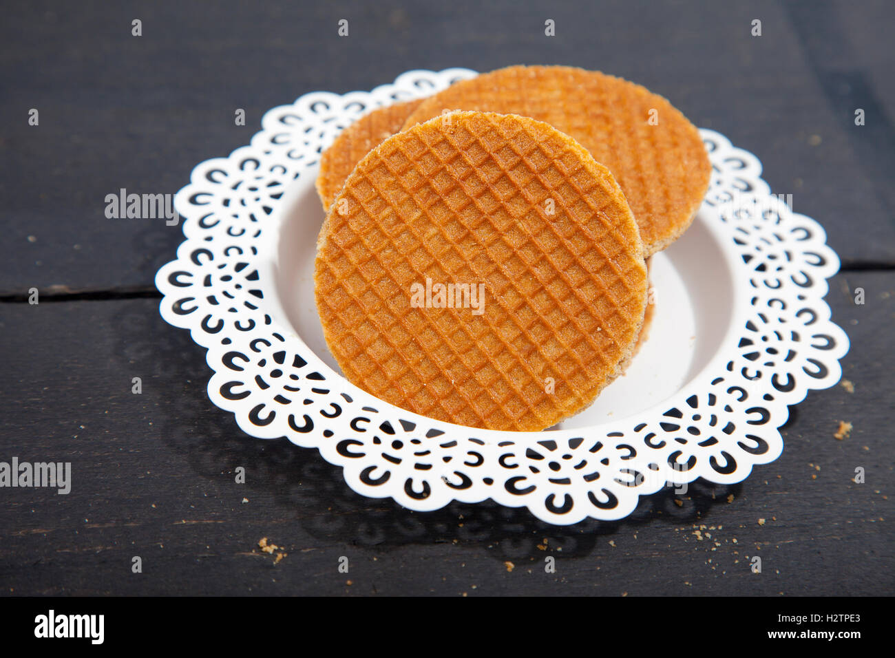 Dutch cookie stroopwafels on white plate on black wooden background Stock Photo