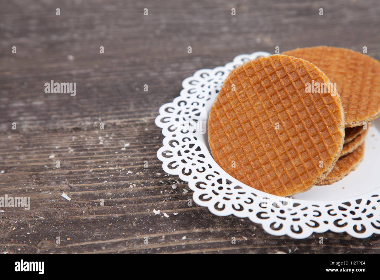 Dutch cookie stroopwafels on white plate on brown wooden background Stock Photo