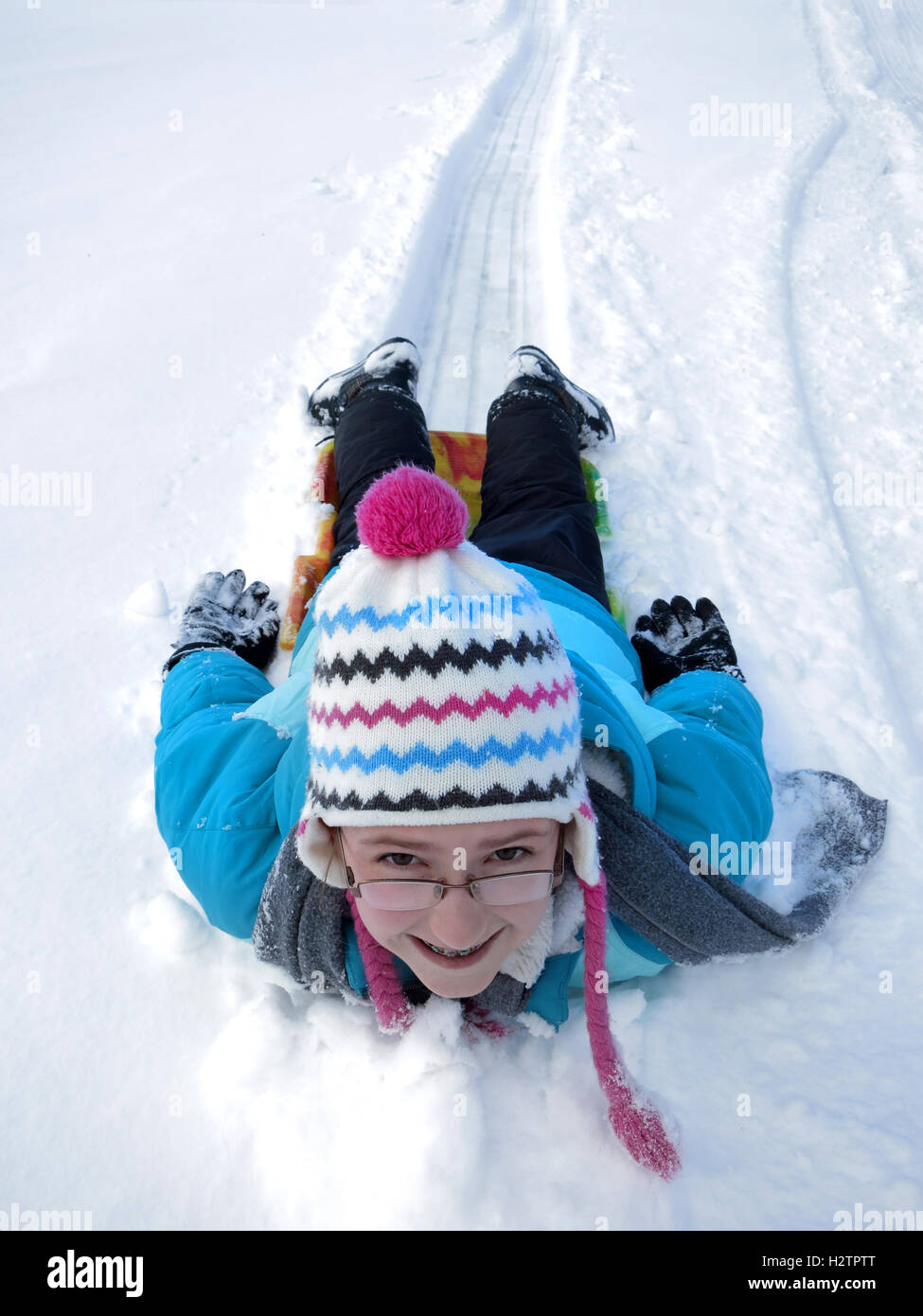 Kids sledding down snowy hill on sled fast speed Stock Photo