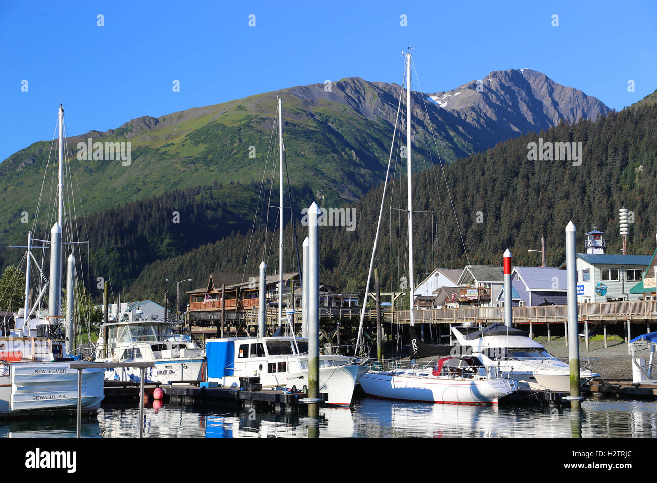 Sail boats docked in harbor with mountains in the background Seward Alaska Stock Photo