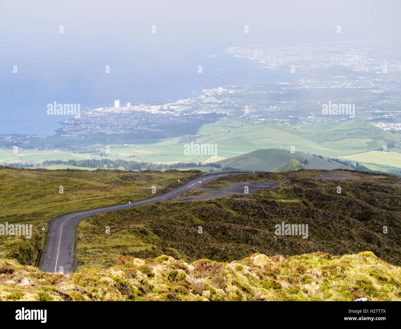 Mountain Road Above Lagoa in the Azores. The road to Lagoa do Fogo rises high above the coastal plain and the city of Lagoa. Stock Photo