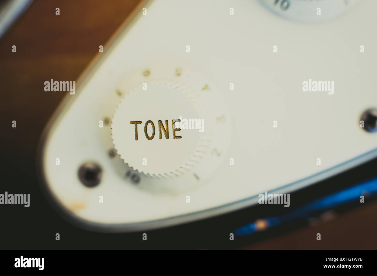 Electric guitar tone knob detail vintage light effect and selective focus, view from the top Stock Photo
