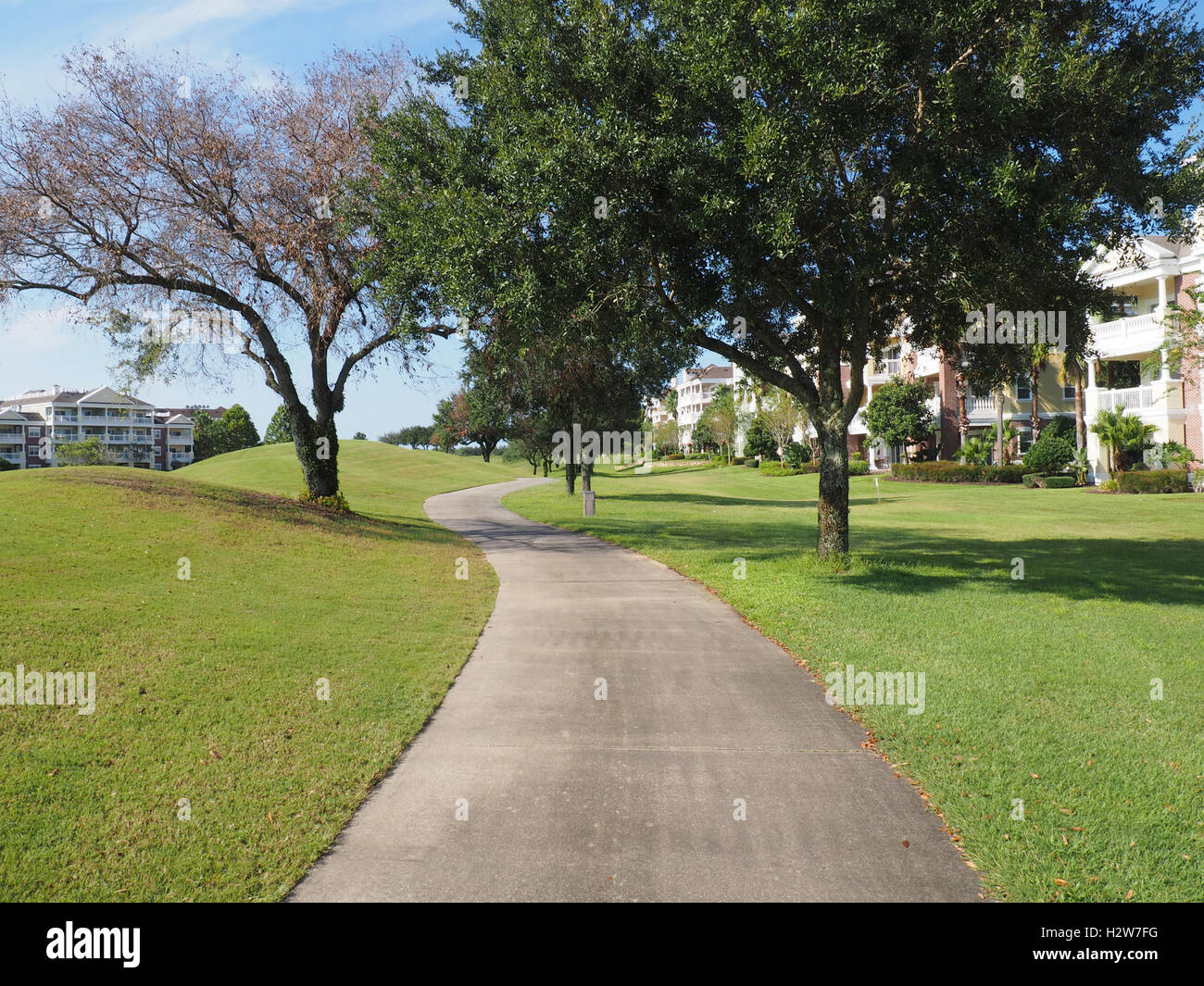 macadam path or walkway by a golf course and trees Stock Photo