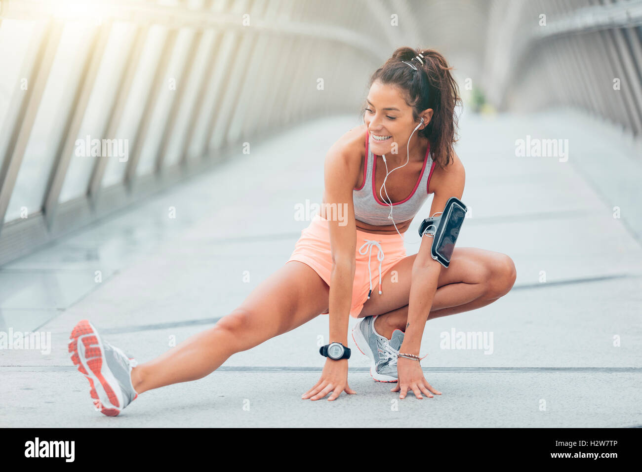 young fitness woman runner stretching legs before run Stock Photo