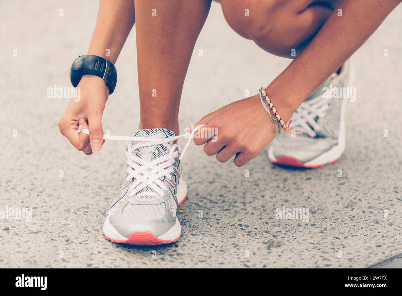 Woman tying sports shoe Stock Photo