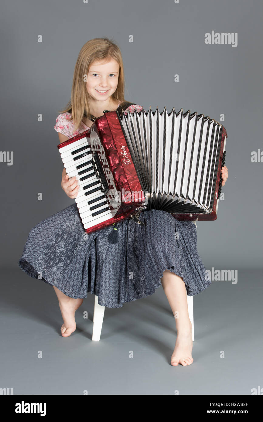 Girl playing her accordion with happy expression Stock Photo Alamy